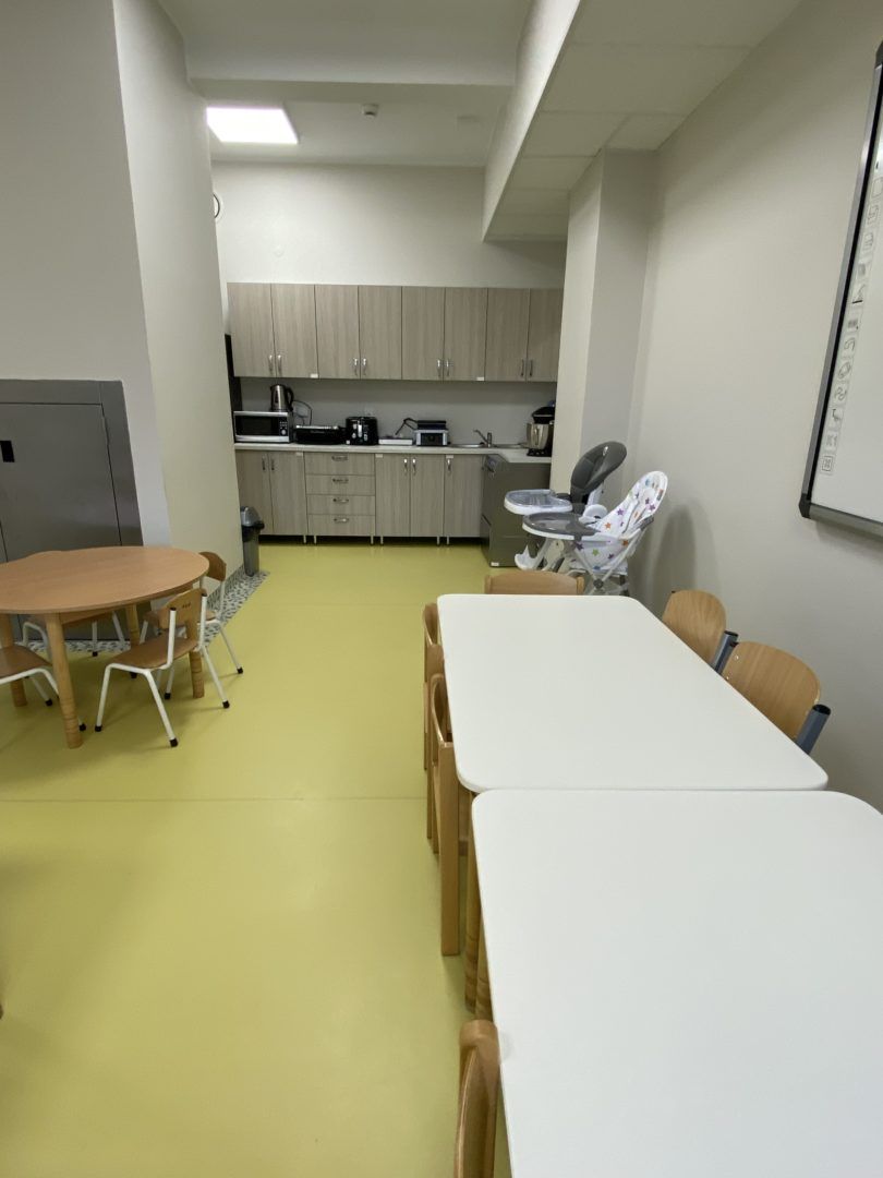 Zdjęcie przedstawia jadalnię oraz kuchnie w placówce terapeutycznej dla dzieci